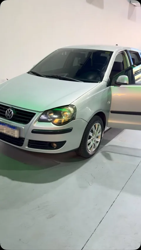 Volkswagen Polo prata com a porta do motorista aberta dentro da Evotek, o carro do atendimento que a loja publicou em vídeo.